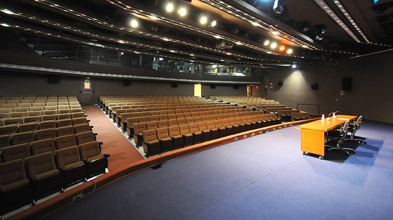 Imagen del Escenario del Centro Cultural de Murcia con mesas y sillas preparadas para conferencia